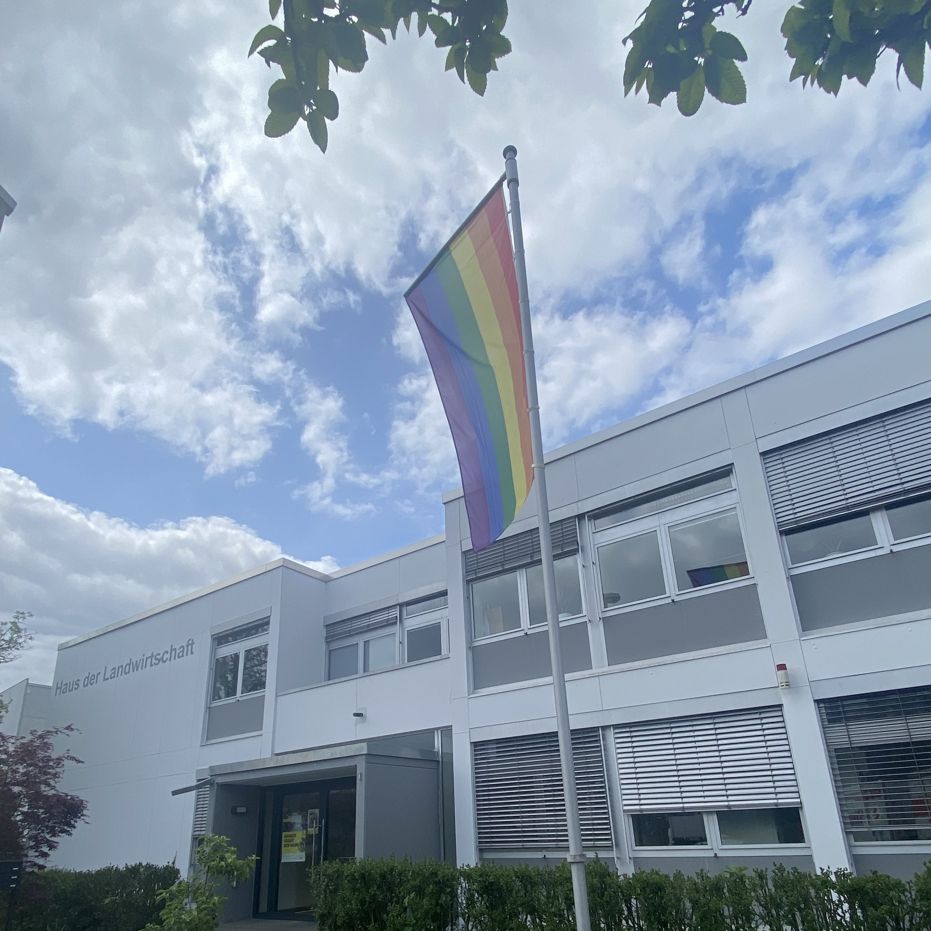 Regenbogenflagge an Mast rechts im Bild vor dem Gebäuse der Hauses der Landwirtschaft